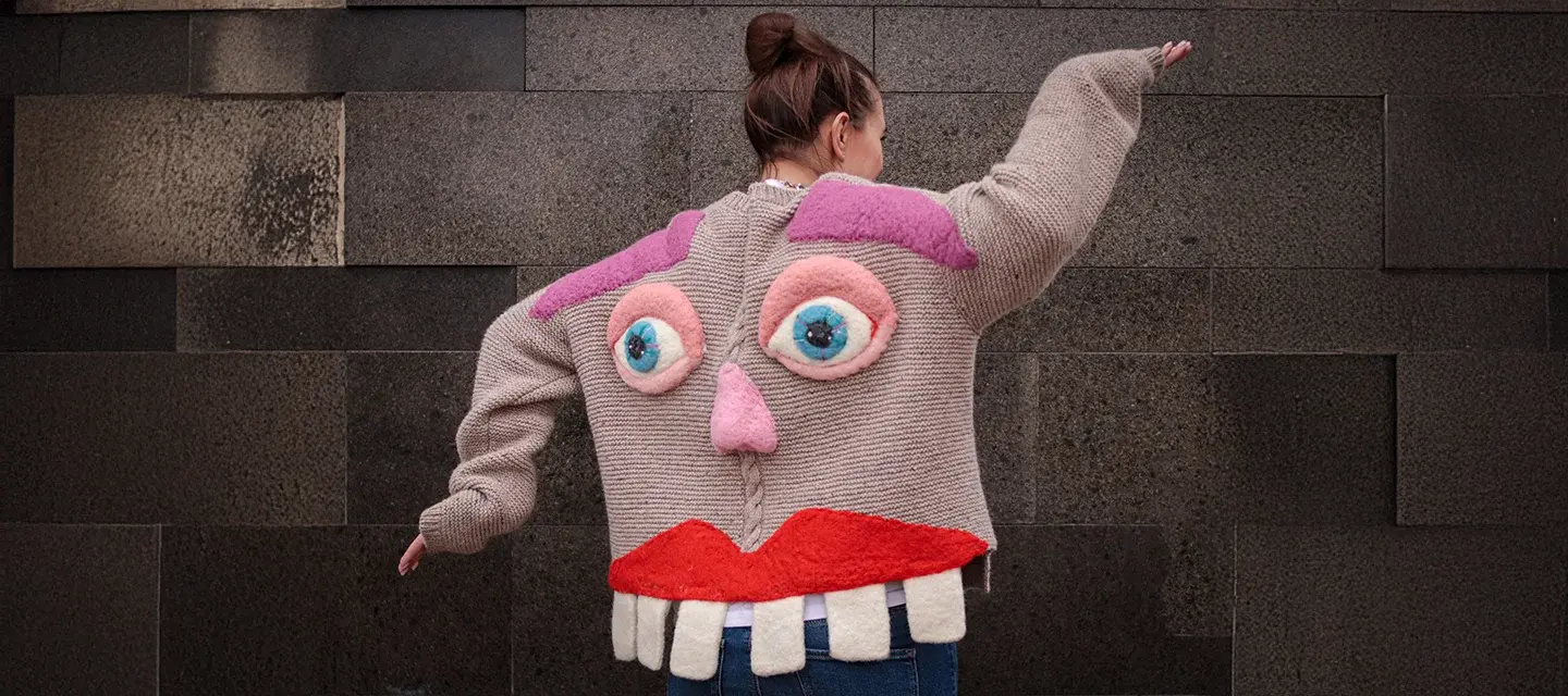 A woman dancing in a knitted jacket with face and teeth