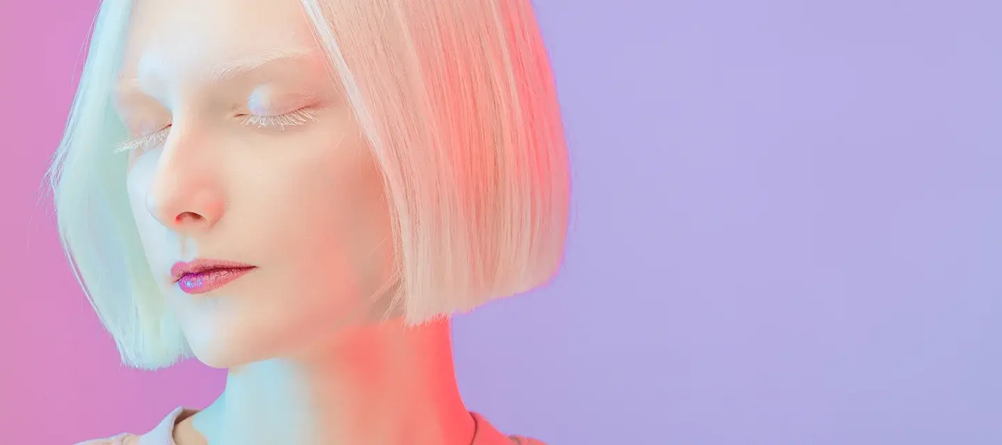 A beautiful albino girl with bob hair style and long lashes under neon light A beautiful albino girl with bob hair style and long lashes under neon light