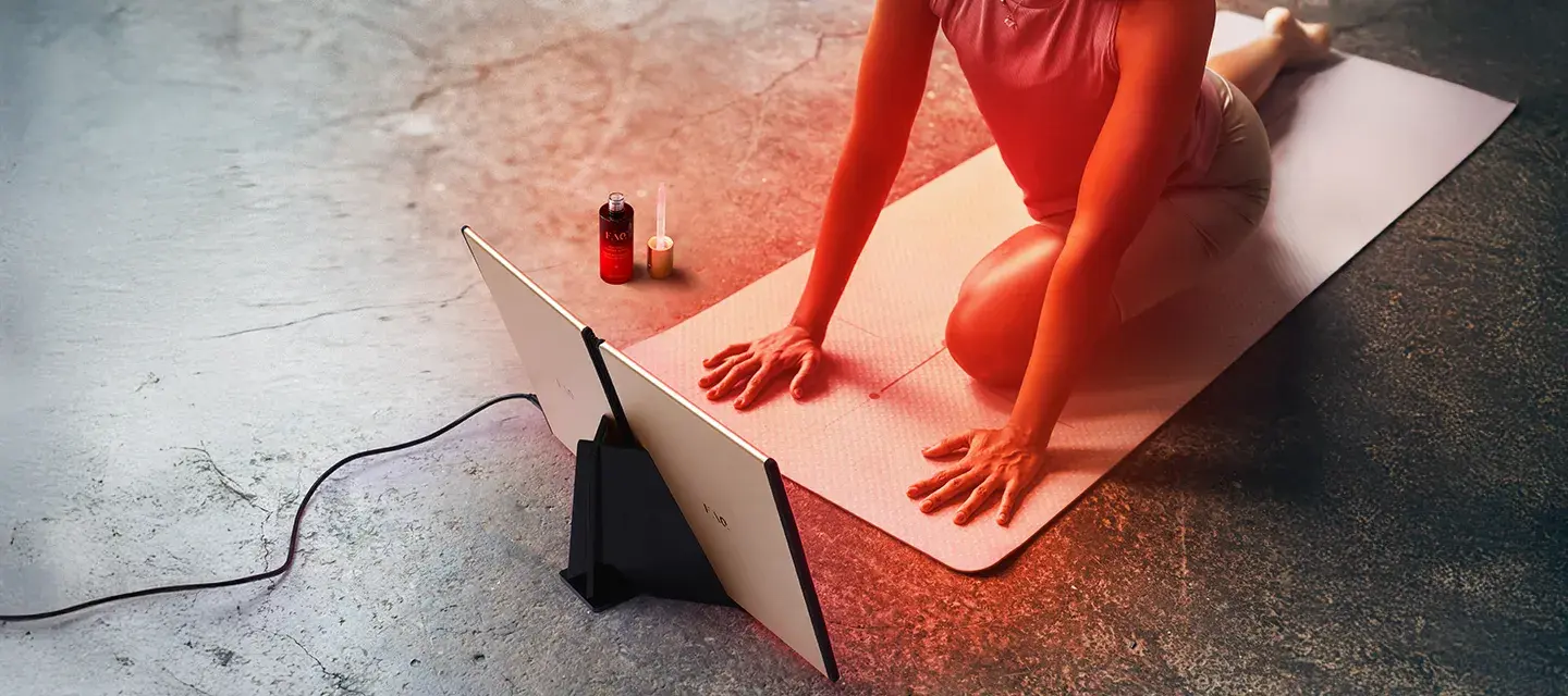 Woman doing yoga in fron of FAQ DUAL LED PANEL red light therapy at home device