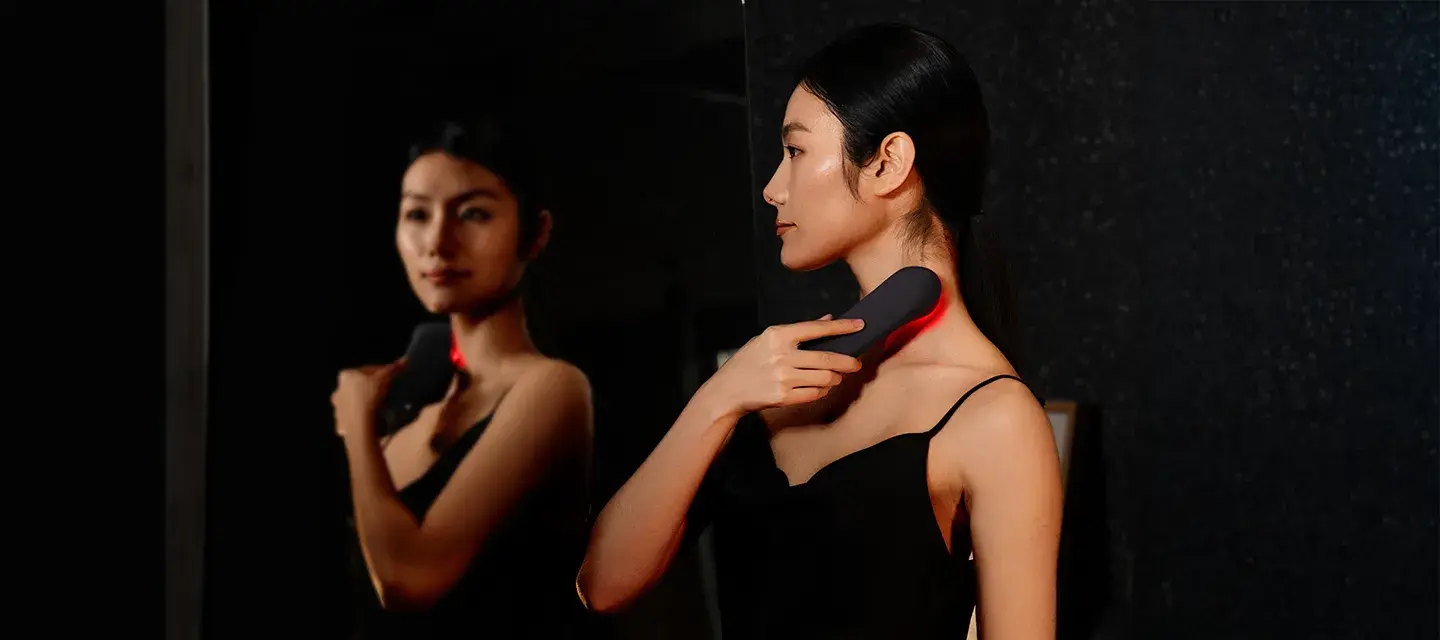 A woman using FAQ 502 full-spectrum red light therapy