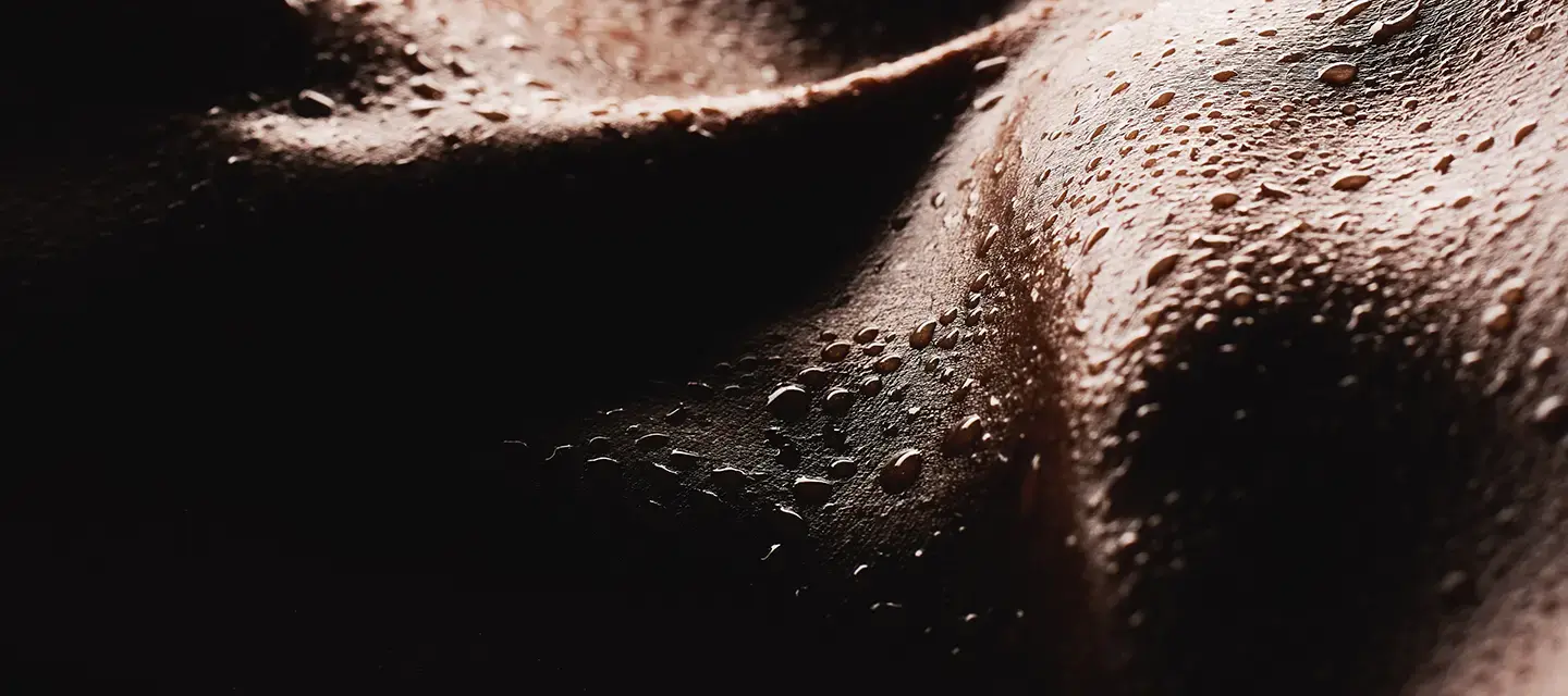 A closeup of dark skin with bads of sweat on it