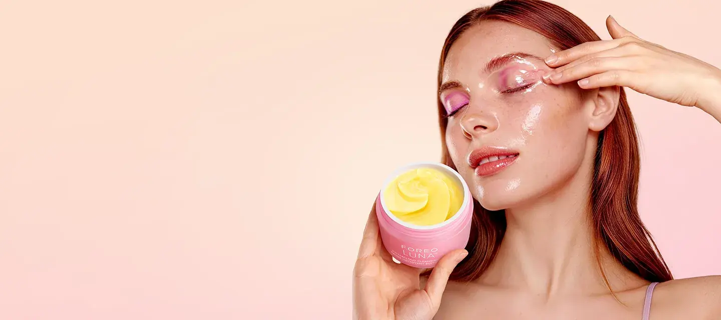 A woman using LUNA Buttercloud Cleansing Balm