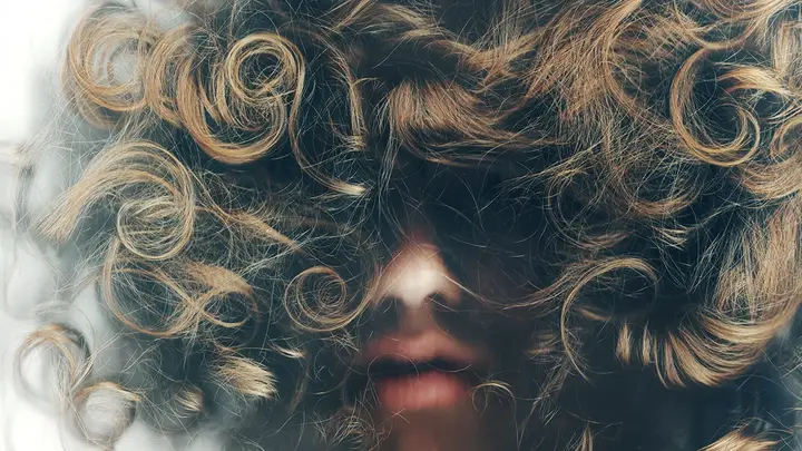 A woman with curly hair from frog perspective