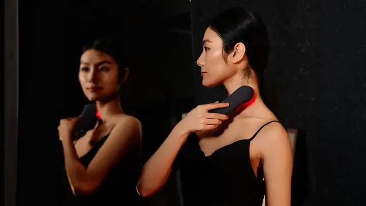 A woman using FAQ 502 full-spectrum red light therapy