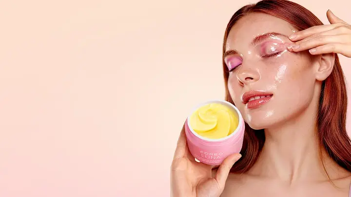 A woman using LUNA Buttercloud Cleansing Balm