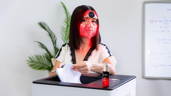 A woman using FAQ 202 mask in the office