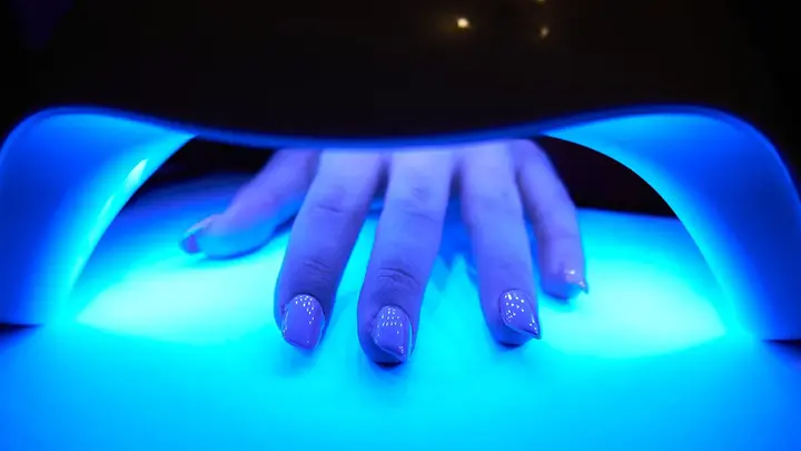 gel manicure curing in a blue light for nails manicure 