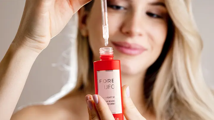A woman using UFO LED serum for red light therapy