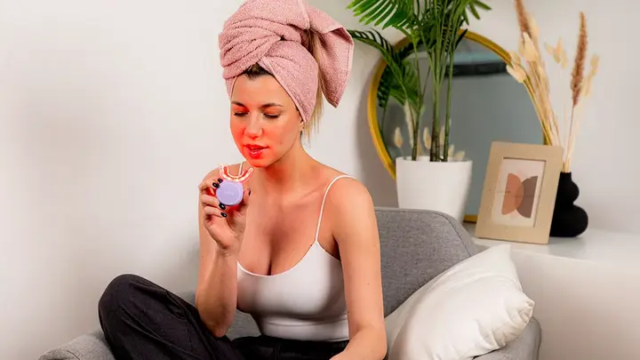 A young woman with a towel on her hair using issa TEETH WHITENING SET