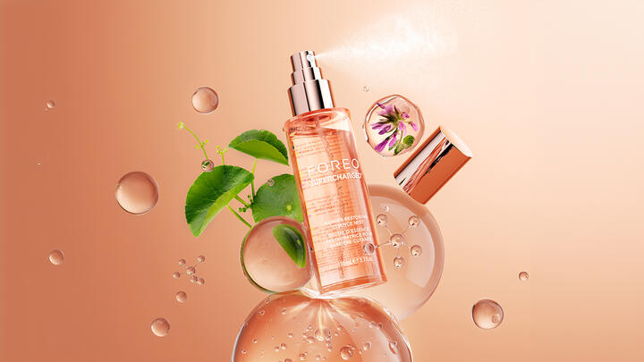 SUPERCHARGED Essence Mist floating in a peach-colored space, with Centella asiatica, purple flower, and molecules