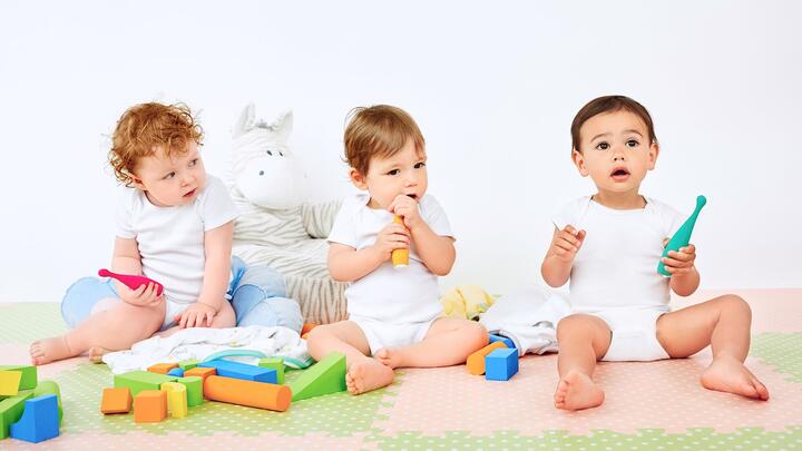 ISSA mini toothbrushes Three happy babies playing with ISSA brushes